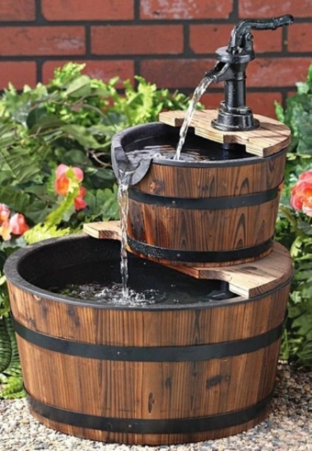 une petite fontaine rustique à plusieurs niveaux composée de seaux en bois et dotée d'un robinet noir est une idée créative pour un espace rustique une petite fontaine rustique à plusieurs niveaux composée de seaux en bois et dotée d'un robinet noir est une idée créative pour un espace rustique