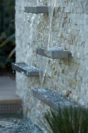 a creative modern fountain of a faux stone wall and metal shelves is a lovely idea for a modern garden