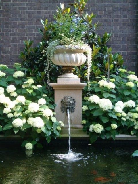 une élégante fontaine vintage avec un bol avec de la verdure sur le dessus et une grande piscine ou un étang pour y couler est une belle idée pour un jardin élégant d'inspiration vintage une élégante fontaine vintage avec un bol avec de la verdure sur le dessus et une grande piscine ou un étang pour y couler est une belle idée pour un élégant jardin d'inspiration vintage
