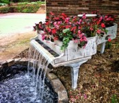 a unique garden fountain of a whitewashed piano with bold blooms on top is a lovely idea for a garden