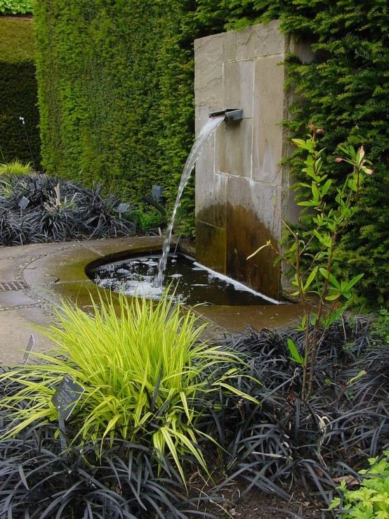a modern fountain clad with stone, with a metal touch is a lovely idea for a modern or zen-like garden
