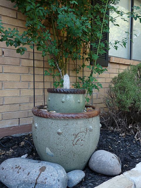 a green porcelain bowl fountain surrounded with rocks is a lovely idea for a zen garden, it will bring harmony and beauty to the space