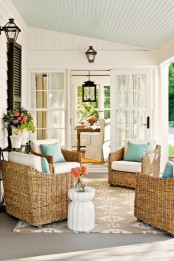 a rustic summer porch with wicker chairs, turquoise pillows and some potted blooms and greenery