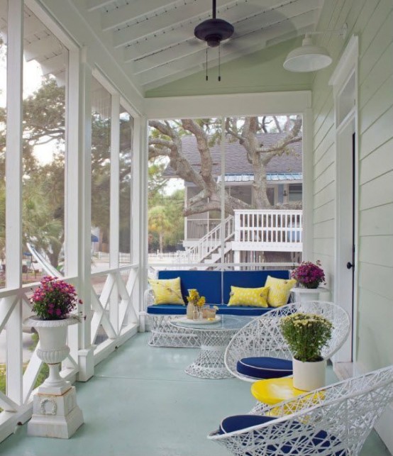 a colorful summer porch in bright yellow and blue, with catchy metal furniture and potted flowers