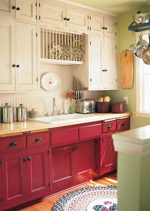 a bright kitchen with neutral and fuchsia cabinets, a neutral backsplash and some vintage decor