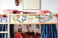 kura bed covered with scraps of floral wallpaper and with a cozy reading nook on the floor