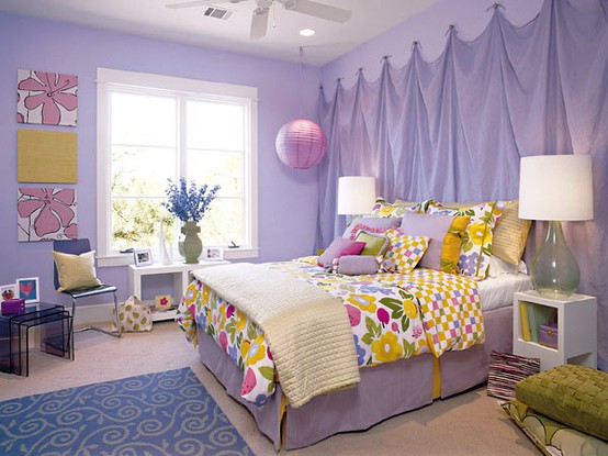 a lilac bedroom with curtains instead of a headboard, a lilac bed and colorful artwork and bedding, a blue printed rug and green cushions is a lovely idea for a romantic person