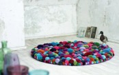 a colorful round pompom rug is a bright accessory that you may enjoy and with which you may accent your space