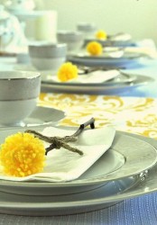 billy balls made of sticks and yellow pompoms are a nice way to accent place settings for spring