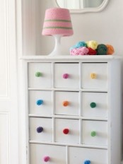 colorful pompom knobs and a colorful crochet lampshade for cozying up the interior and make it fun