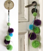 a colorful green, blue and purple pompom hanging can accent a door or some other item or space and add color to it