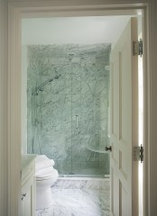 a laconic white marble bathroom with a shower space and a vanity – you won’t need more than that