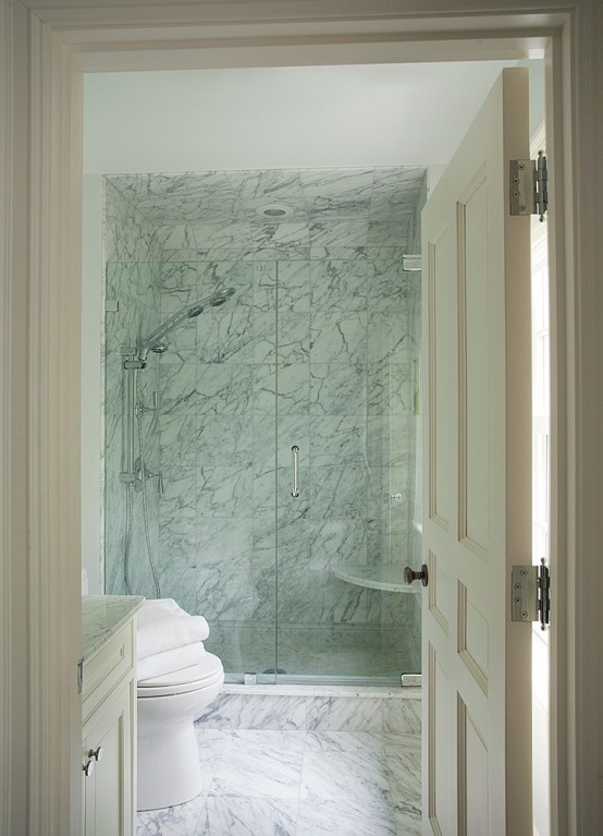 a laconic white marble bathroom with a shower space and a vanity - you won't need more than that