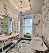 a luxurious vintage-inspired bathroom clad with white marble completely, with a metallic tub and sinks on stands