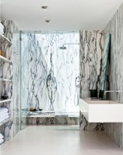 a statement contemporary bathroom all done with white and black marble on the walls, in the shower space and with marble shelves