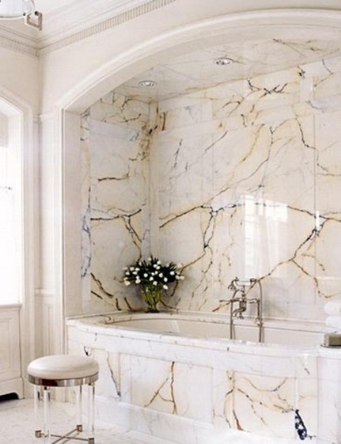 a chic and refined bathroom with a tub space all clad with catchy marble panels