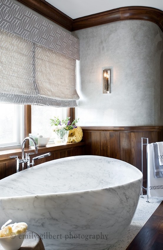 a contemporary luxurious bathroom done with dark stained wood and white marble, with cchic hardware and printed shutters