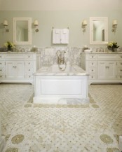 a vintage-inspired white bathroom with white vanities and a tile floor and a sink zone with white marble plus a tub clad with it, too
