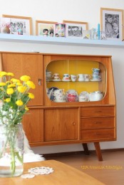 a light-stained mid-century modern buffet with drawers, usual storage compartments and glass-enclosed parts is a very stylish and cool idea for a modern space