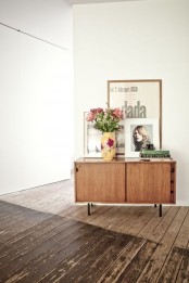 a stained mid-century modern cabinet with sliding doors and black legs is a stylish idea for a mid-century modern space