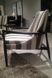 a stylish striped chair with a black frame is a cool idea for a modern or vintage space, it catches an eye