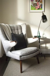 a grey wingback chair with tall armrests, with wooden legs is a stylish idea for a modern or vintage space, here a classic design is paired with modern upholstery