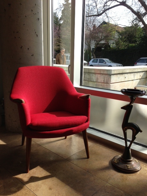 a bold red mid-century modern chair with a stained frame and legs and bold red upholstery that makes a statement with color