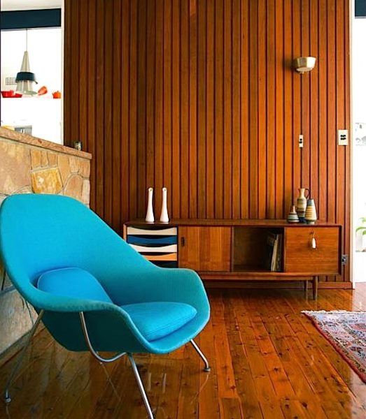 a cozy and bold blue chair with pillows is a catchy and bright idea for a mid-century modern space and its shape welcomes to sit on it
