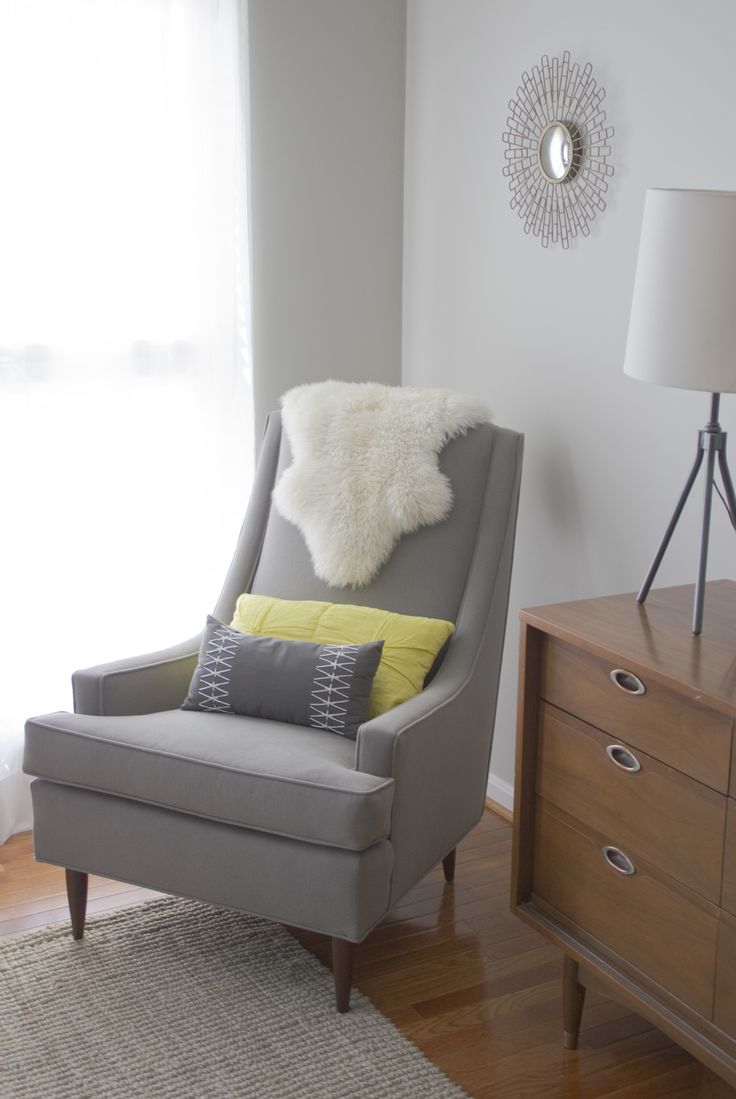a grey Scandinavian chair with wooden legs and a grey and a yellow pillow plus some faux fur is a cool solution to rock