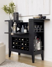 a black home mini bar with plenty of storage space, greenery, lots of bottles and other stuff