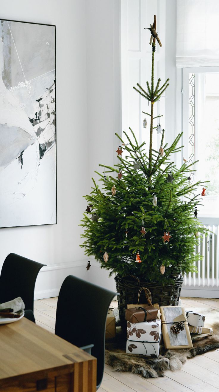 a modern Christmas tree in a basket, with mismatching ornaments, some gifts wrapped in natural paper is a lovely idea for winter