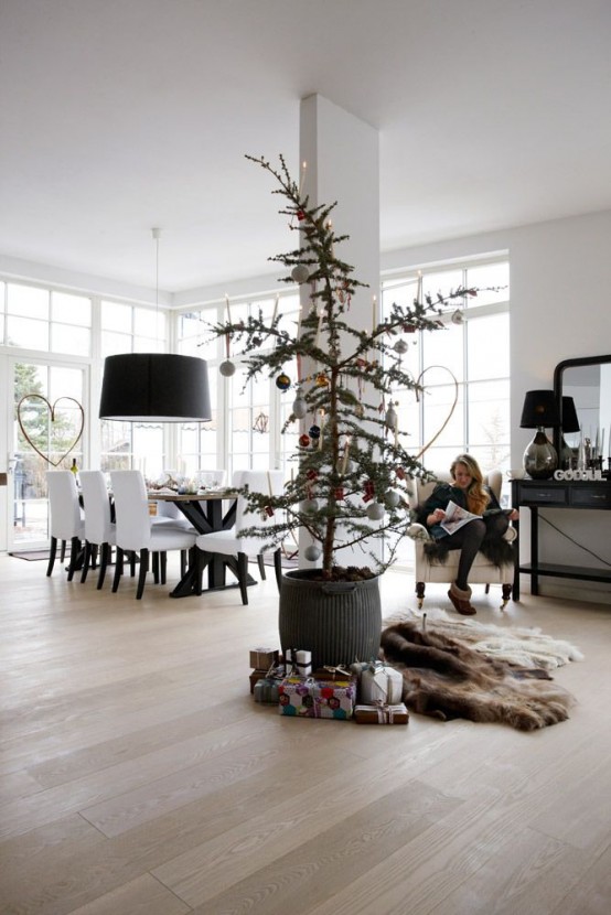 a modern Christmas tree decorated with a small amount of mismatching ornaments and gift boxes wrapped in colorful paper for a lovely and cool look