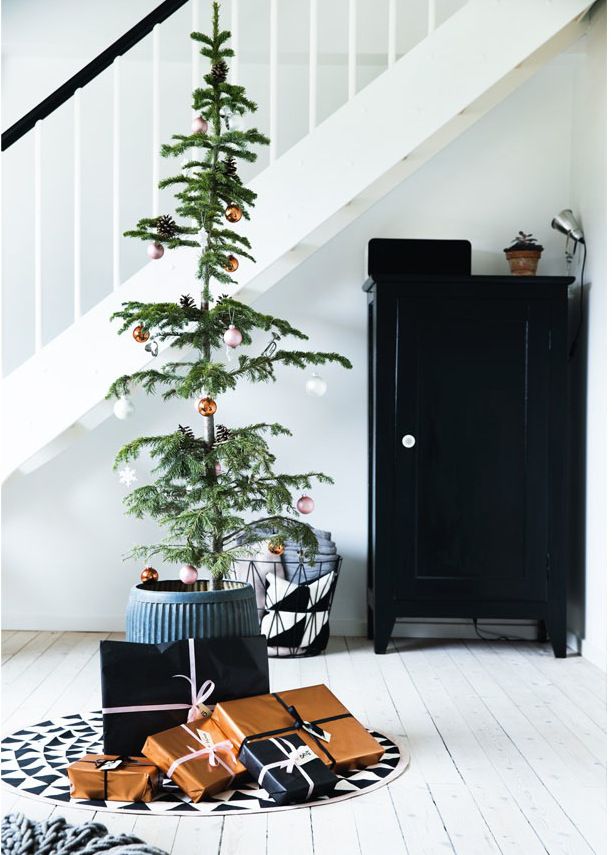 a modern Christmas tree decorated with copper, pink and white ornaments, black and copper gift boxes for a modern or Scandi space