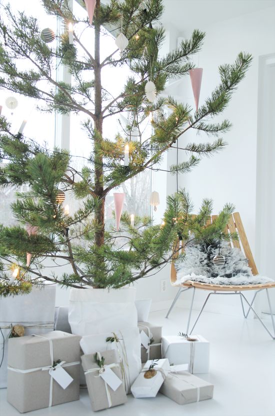 an oversized potted pine tree with black and white ornaments plus lights is a lovely idea for a serene modern or Scandi space