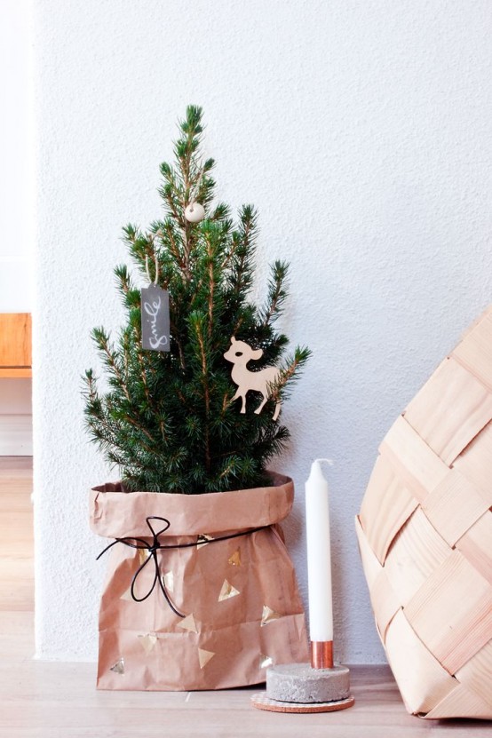 a small Christmas tree in a paper bag, with just a couple of wooden ornaments is a lovely idea for a rustic space