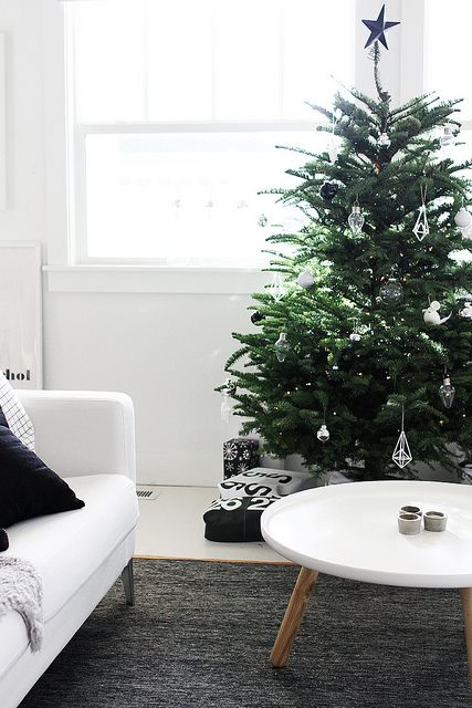 a Christmas tree with black, white and clear glass ornaments is a pretty idea for a modern space and it looks amazing