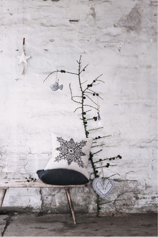 a dried branch with pinecones and two fabric ornaments - a bird and a heart for a minimal Nordic look