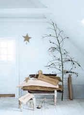 a dried branch with pinecones and candles is a chic natural and minimalist decor idea for Christmas