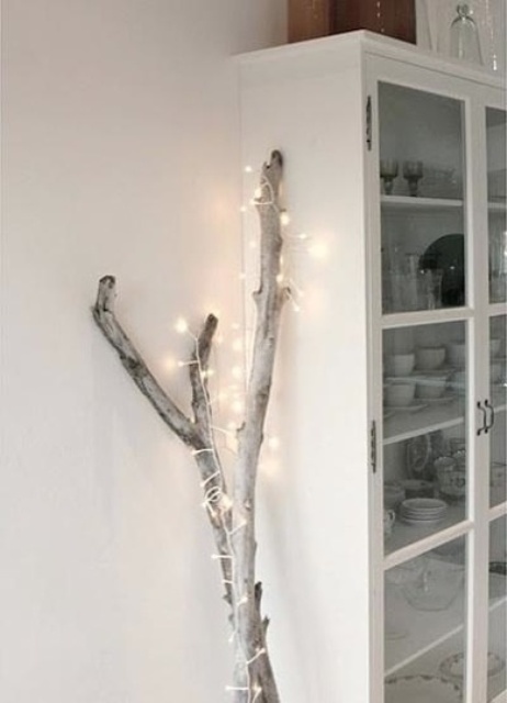 branches wrapped with lights are a nice Christmas tree alternative that can be used in any space