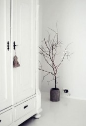 dried branches in a pot with lights are an amazing Christmas tree alternative for a minimalist space