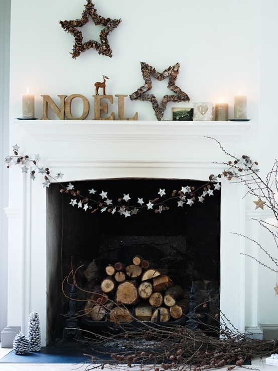 wooden letters, neutral candles, wood stick stars, a star and dried pinecone garland and firewood for a natural minimal holiday look