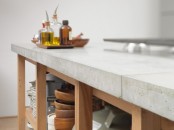 a wooden kitchen island with a concrete countertop looks modern and fresh and is very contrasting