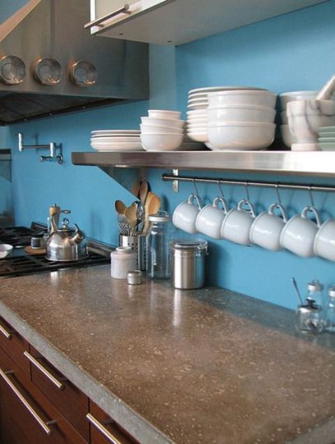 a blue kitchen with chocolate brown cabinets and a polished concrete countertop looks bold and catchy