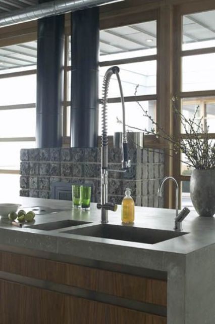 an industrial modern kitchen with wooden cabinets clad with concrete countertops looks super bold and very catchy