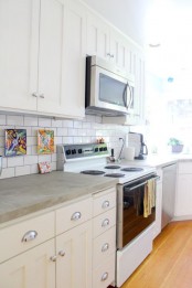 a neutral farmhouse kitchen with concrete countertops and a white subway tile backsplash for a chic and simple look