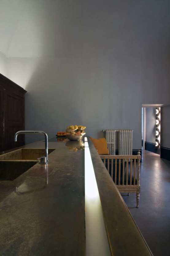 an industrial kitchen with a large kitchen island with a polished concrete countertop that makes a statement