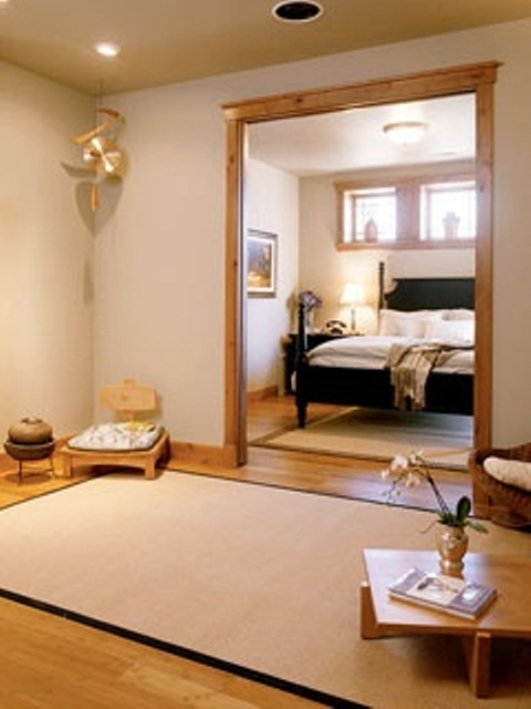 a small and peaceful meditation space with a large rug, low furniture and Asian decor