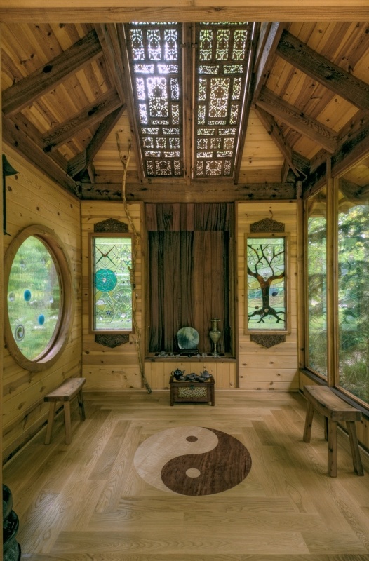 a unique meditation space fulled clad with wood and plywood and with artworks and mosaic windows