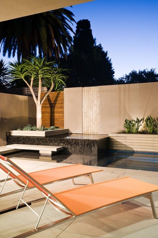 a minimalist terrace with a pool and a pond, with a tile floor, some growing trees and plants and simple orange loungers