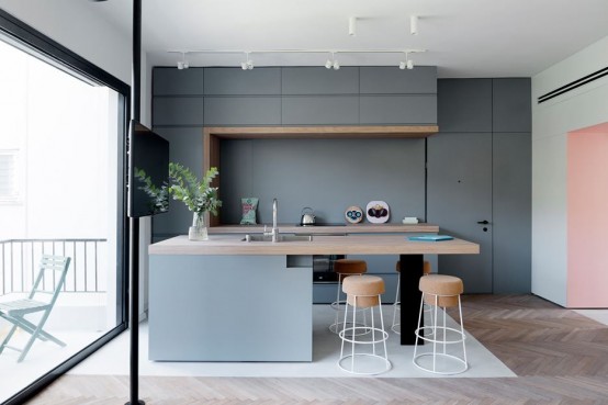 a minimalist grey kitchen with sleek cabinets, a large kitchen island with a butcherblock countertop, matchign cork stools to eat here